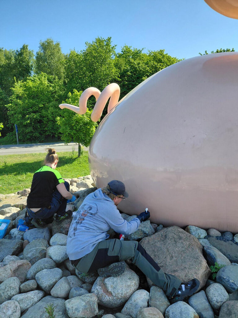 Museomestarit poistamassa mustaa spraymaalia Posankan pinnoilta.